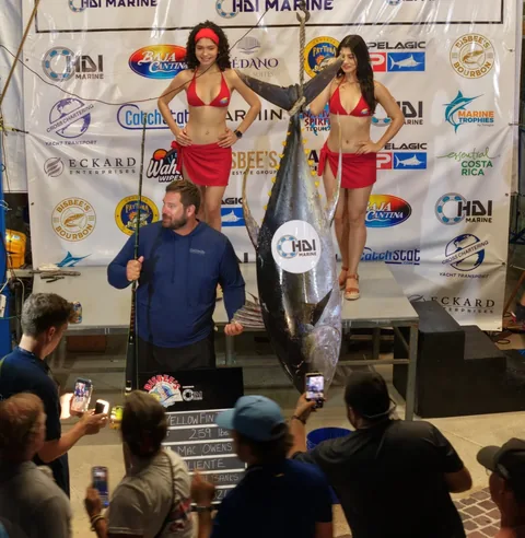 El atún aleta amarilla de Caliente en la estación de pesaje, con el tablero que muestra 259 libras y al pescador Mac Owens