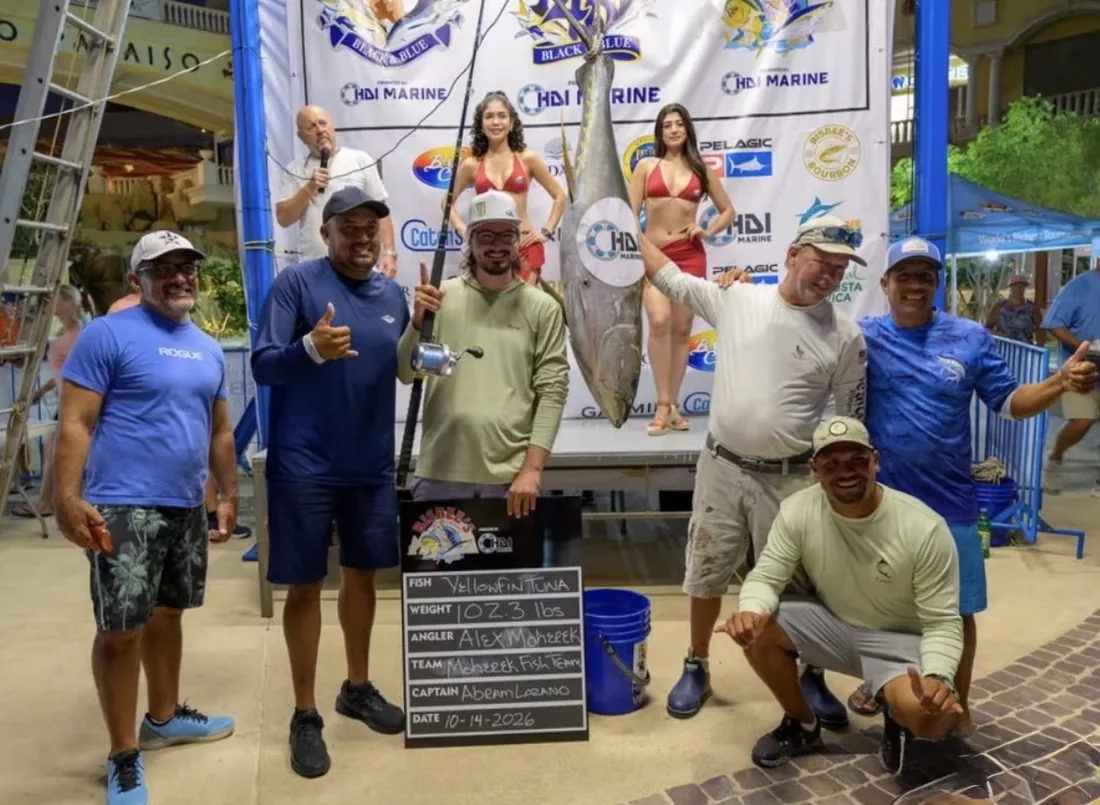 The Mohereek fishing team’s 102.3-pound yellowfin tuna at the Bisbee’s October 14, 2026 weigh-in, with a board recording the weight, angler Alex Mohereek and captain Abraham Lozano